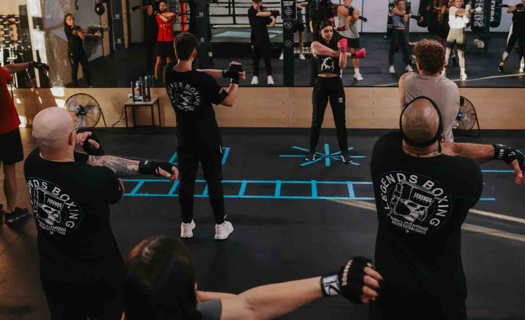 Legends Boxing class with multiple members throwing punches together on the main floor