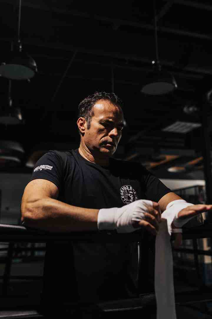 A Legends Boxing coach carefully wrapping hands before a session
